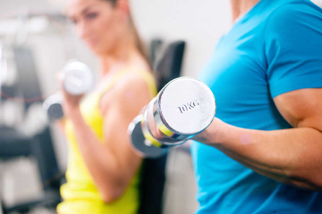 Couple training for fitness in gym with weigts